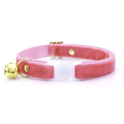 A dusky pink cat collar with a gold bell