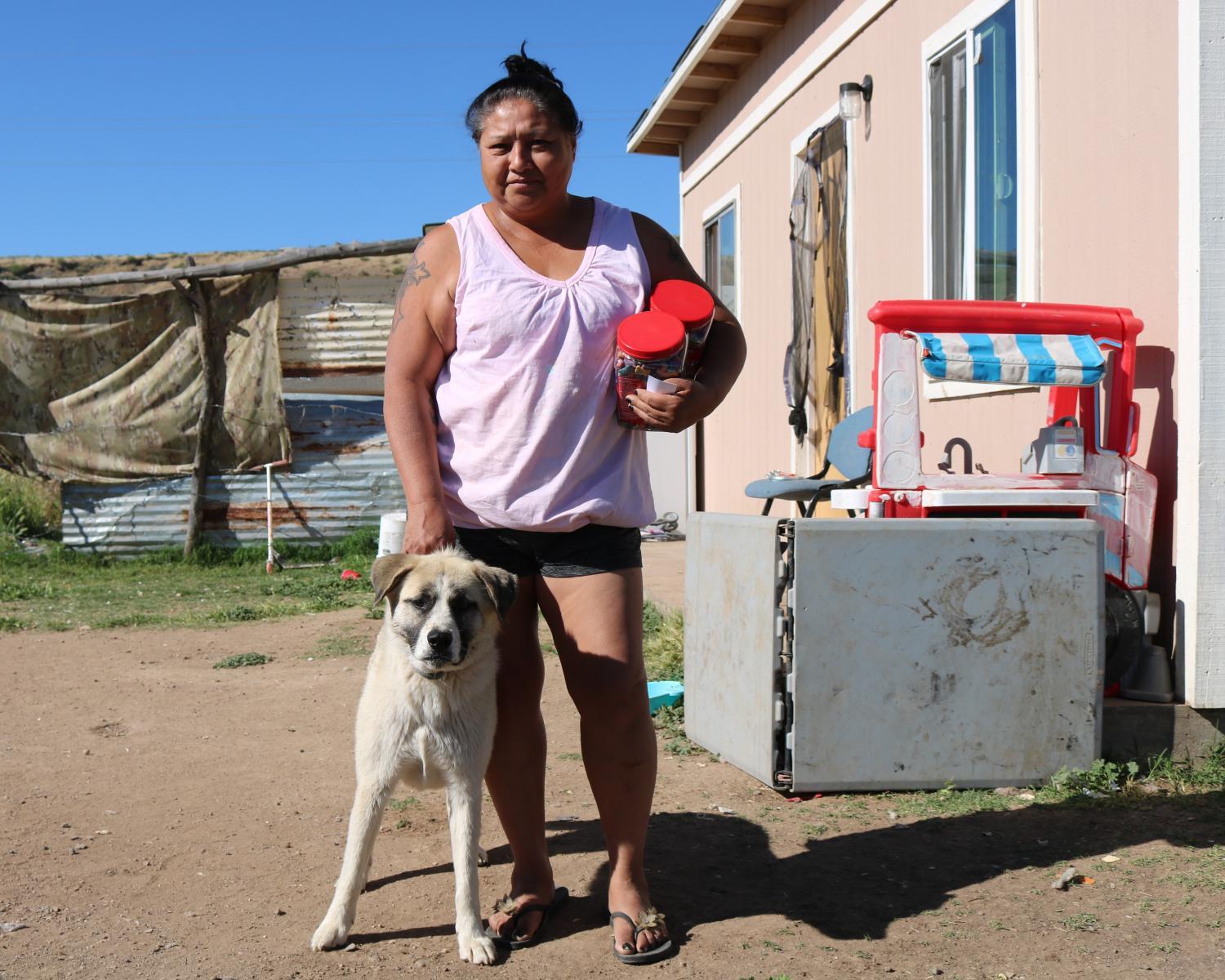 Veronica Martinez holds onto a shipment of pet food that the Geronimo Animal Rescue Team delivered to her household in late-April 2024.